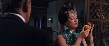 Movie still from “Gambit” (1966), directed by Ronald Neame – A woman sitting in front of a chair with her eyes closed; Close Up shot, Over the shoulder angle