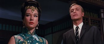 Movie still from “Gambit” (1966), directed by Ronald Neame – A man and a woman standing next to each other; Close Up shot, Low angle