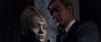 Movie still from “Gambit” (1966), directed by Ronald Neame – A man in a suit looking at a mannequin head; Close Up shot, Low angle