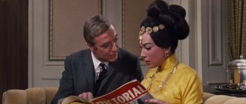 Movie still from “Gambit” (1966), directed by Ronald Neame – A man and a woman looking at a magazine; Close Up shot, Over the shoulder angle