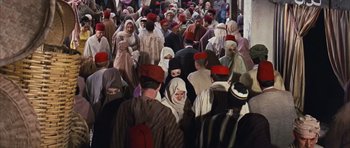 Movie still from “Gambit” (1966), directed by Ronald Neame – A group of people wearing red hats and white robes; Wide shot, High angle