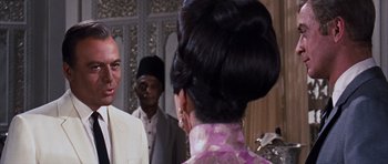 Movie still from “Gambit” (1966), directed by Ronald Neame – A man and a woman are talking to each other; Close Up shot, Over the shoulder angle