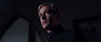 Movie still from “Gambit” (1966), directed by Ronald Neame – A person wearing a black shirt; Close Up shot, Low angle