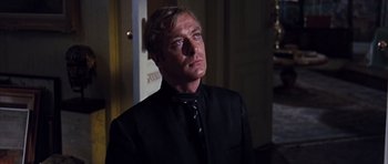 Movie still from “Gambit” (1966), directed by Ronald Neame – A man in a black shirt and a black tie; Close Up shot, Low angle