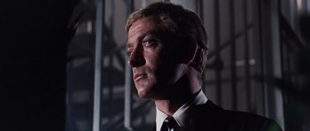 Movie still from “Gambit” (1966), directed by Ronald Neame – A man in a suit and tie; Close Up shot, Low angle