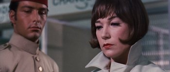 Movie still from “Gambit” (1966), directed by Ronald Neame – A person wearing a white shirt; Close Up shot, Low angle