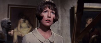 Movie still from “Gambit” (1966), directed by Ronald Neame – A person with short brown hair; Close Up shot, Over the shoulder angle