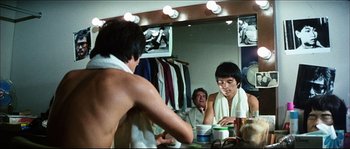 Movie still from “Game of Death” (1978), directed by Robert Clouse – A group of people in a dressing room; Medium shot, Over the shoulder angle
