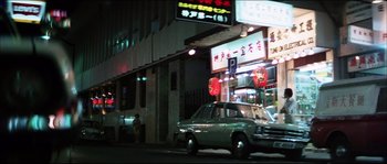 Movie still from “Game of Death” (1978), directed by Robert Clouse – A car parked on the side of the street at night; Wide shot, Low angle