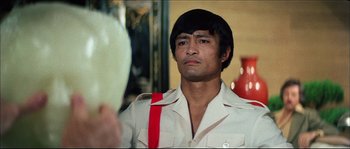 Movie still from “Game of Death” (1978), directed by Robert Clouse – A person wearing a shirt and tie; Close Up shot, Over the shoulder angle