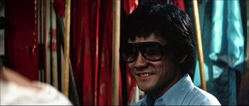 Movie still from “Game of Death” (1978), directed by Robert Clouse – A person wearing sunglasses; Close Up shot, Low angle