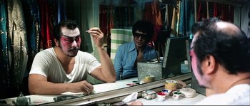 Movie still from “Game of Death” (1978), directed by Robert Clouse – Two men sitting at a table in front of a mirror; Medium shot, Over the shoulder angle