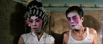 Movie still from “Game of Death” (1978), directed by Robert Clouse – A couple of people that are sitting on a couch; Close Up shot, High angle