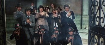 Movie still from “Game of Death” (1978), directed by Robert Clouse – A group of men in suits and hats are holding guns; Wide shot, High angle