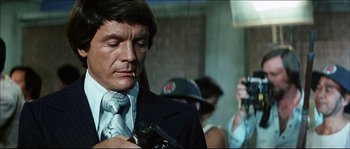 Movie still from “Game of Death” (1978), directed by Robert Clouse – A person wearing a suit and a tie; Close Up shot, Low angle