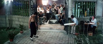 Movie still from “Game of Death” (1978), directed by Robert Clouse – A group of people watching a man play baseball; Wide shot, Over the shoulder angle
