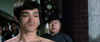 Movie still from “Game of Death” (1978), directed by Robert Clouse – A person with a hat; Close Up shot, Low angle