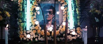 Movie still from “Game of Death” (1978), directed by Robert Clouse – Candles and flowers surround a portrait of a young man; Medium shot, Low angle