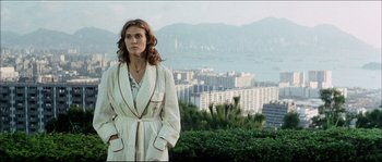 Movie still from “Game of Death” (1978), directed by Robert Clouse – A woman in a white robe stands in front of a city skyline; Medium shot, Low angle