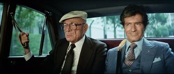 Movie still from “Game of Death” (1978), directed by Robert Clouse – An old man sitting in the back seat of a car; Close Up shot, Over the shoulder angle