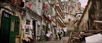 Movie still from “Game of Death” (1978), directed by Robert Clouse – A man walking down a street near a building; Extreme Wide shot, High angle