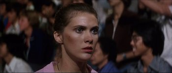 Movie still from “Game of Death” (1978), directed by Robert Clouse – A woman that is looking into the distance; Close Up shot, Low angle