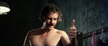 Movie still from “Game of Death” (1978), directed by Robert Clouse – A shirtless man giving a thumbs up; Close Up shot, Low angle