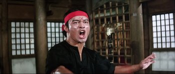 Movie still from “Game of Death” (1978), directed by Robert Clouse – A man with a red bandage on his head; Medium shot, Low angle