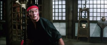 Movie still from “Game of Death” (1978), directed by Robert Clouse – A man with a red bandage on his head; Medium shot, Low angle