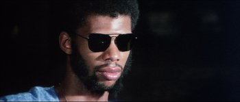 Movie still from “Game of Death” (1978), directed by Robert Clouse – A person wearing sunglasses; Close Up shot, Low angle
