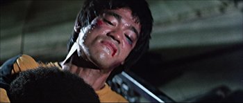 Movie still from “Game of Death” (1978), directed by Robert Clouse – A person with blood on his face; Close Up shot, Low angle
