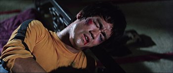 Movie still from “Game of Death” (1978), directed by Robert Clouse – A man with bruises on his face and head; Close Up shot, Overhead angle