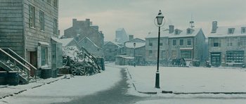 Movie still from “Gangs of New York” (2002), directed by Martin Scorsese – A street light in the middle of a snow covered town; Extreme Wide shot, High angle
