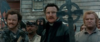 Movie still from “Gangs of New York” (2002), directed by Martin Scorsese – A group of men standing next to each other holding a cross; Close Up shot, Low angle