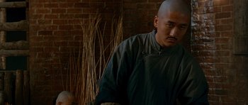 Movie still from “Gangs of New York” (2002), directed by Martin Scorsese – A man with a shaved head standing in front of a brick wall; Close Up shot, Over the shoulder angle
