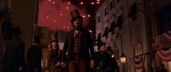 Movie still from “Gangs of New York” (2002), directed by Martin Scorsese – A group of men in top hats walking on a city street; Medium shot, Low angle