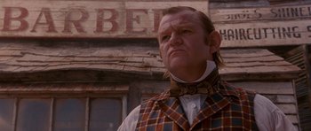 Movie still from “Gangs of New York” (2002), directed by Martin Scorsese – A man in a plaid vest standing in front of a building; Close Up shot, Low angle