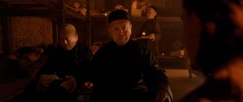 Movie still from “Gangs of New York” (2002), directed by Martin Scorsese – An old man sitting in front of candles; Medium shot, Low angle