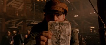 Movie still from “Gangs of New York” (2002), directed by Martin Scorsese – A man holding a piece of paper in front of his face; Close Up shot, Overhead angle