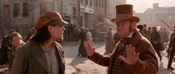 Movie still from “Gangs of New York” (2002), directed by Martin Scorsese – A man in a top hat talking to another man in a hat; Medium shot, Over the shoulder angle