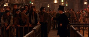 Movie still from “Gangs of New York” (2002), directed by Martin Scorsese – A group of men standing around a wooden fence; Medium shot, Over the shoulder angle