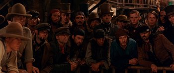 Movie still from “Gangs of New York” (2002), directed by Martin Scorsese – A group of men wearing hats and vests; Medium shot, High angle