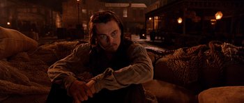 Movie still from “Gangs of New York” (2002), directed by Martin Scorsese – A man sitting on top of a couch in a living room; Medium shot, Low angle