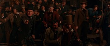 Movie still from “Gangs of New York” (2002), directed by Martin Scorsese – A group of men in top hats sitting on steps; Wide shot, High angle