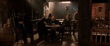 Movie still from “Gangs of New York” (2002), directed by Martin Scorsese – A group of people sitting at a table in a room; Wide shot, High angle