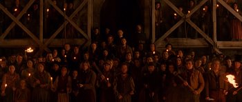 Movie still from “Gangs of New York” (2002), directed by Martin Scorsese – A group of people standing in front of an archway with candles; Wide shot, High angle