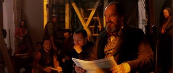 Movie still from “Gangs of New York” (2002), directed by Martin Scorsese – A man with a long beard is reading a newspaper; Medium shot, Over the shoulder angle