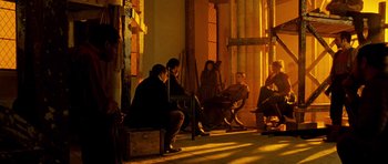 Movie still from “Gangs of New York” (2002), directed by Martin Scorsese – A group of people sitting on a bench in the sunlight; Wide shot, Low angle