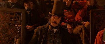 Movie still from “Gangs of New York” (2002), directed by Martin Scorsese – A man in a top hat sitting in front of a group of people; Close Up shot, Low angle