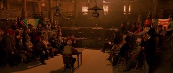 Movie still from “Gangs of New York” (2002), directed by Martin Scorsese – A group of people sitting at a table in a room; Extreme Wide shot, High angle